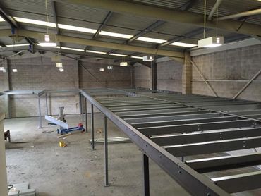 Large industrial warehouse with steel framework under construction.