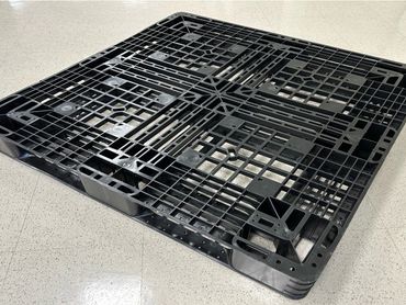 Black plastic pallet on the floor.