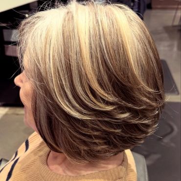Layered bob haircut with blonde highlights on gray hair.