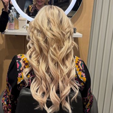 Long, wavy blonde hair styled elegantly in a salon.