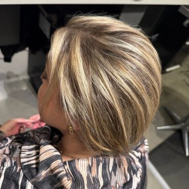 Short layered blonde hairstyle with highlights.