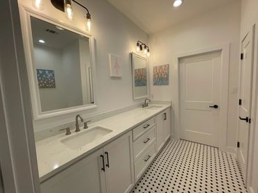 Modern bathroom design with double vanity and custom lighting and finishes by LDC Builds