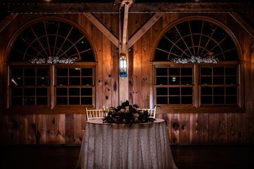 Romantic table setup with floral centerpiece in rustic wooden room.