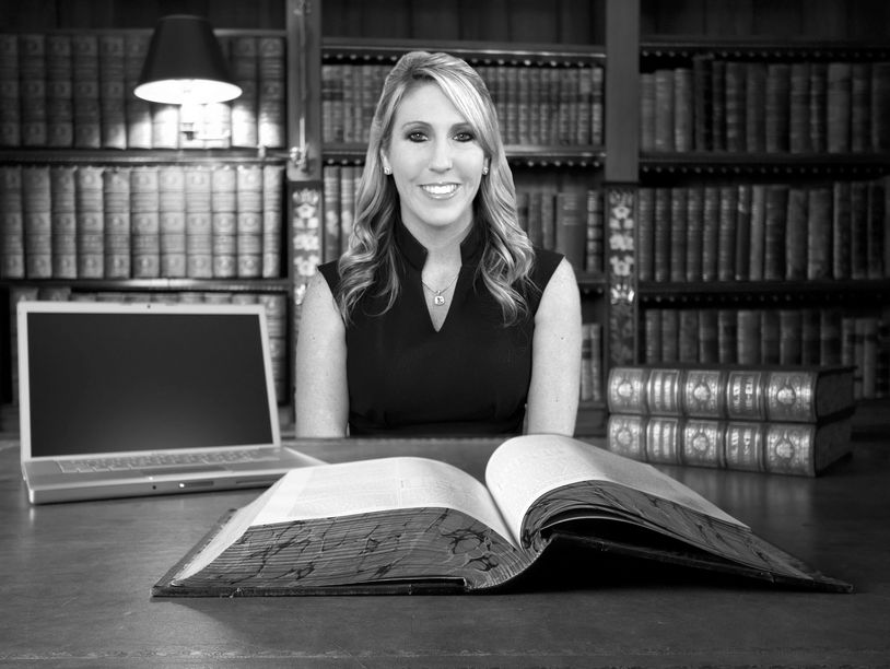 Criminal Defense Attorney Chelsi McLarty sitting at her desk with law book in Fort Worth, TX.