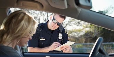 police officer writing a woman a traffic ticket in Fort Worth, TX, and needs Attorney Chelsi McLarty