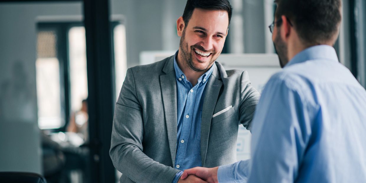 Two business man shake hands . Happy smiling .