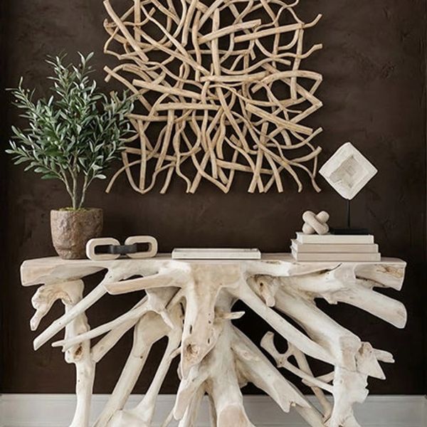 Wooden root table with decorative wall art.