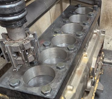 Engine block with cylinder bores and bolts.