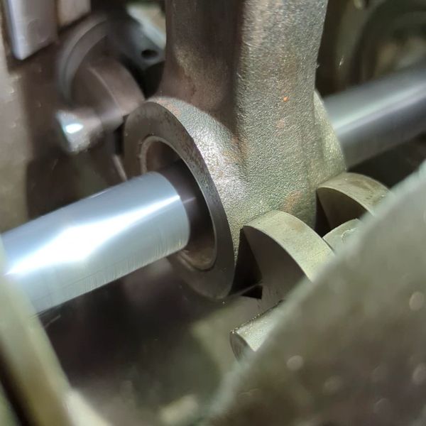 Close-up of a boring bar rotating inside a connecting rod bushing.