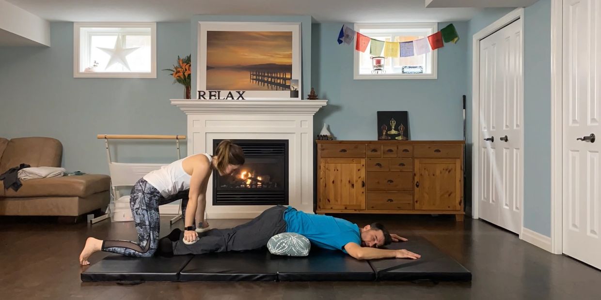 Woman giving man a leg massage in a cozy room.