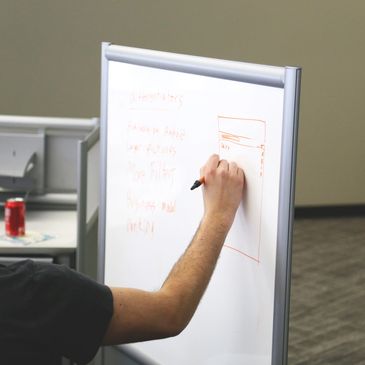 Male right hand drawing on white board