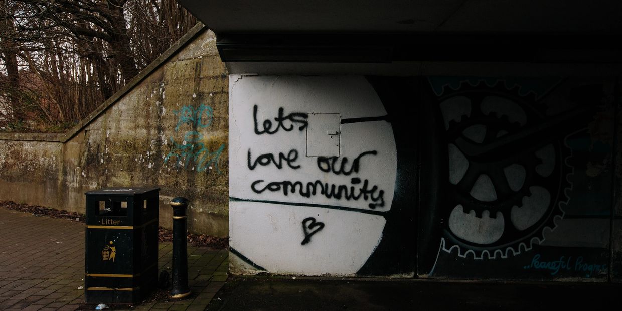 Graffiti saying "lets love our community" on a wall.