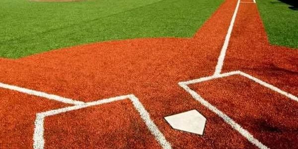 Close-up of a baseball home plate and batter's box on artificial turf.