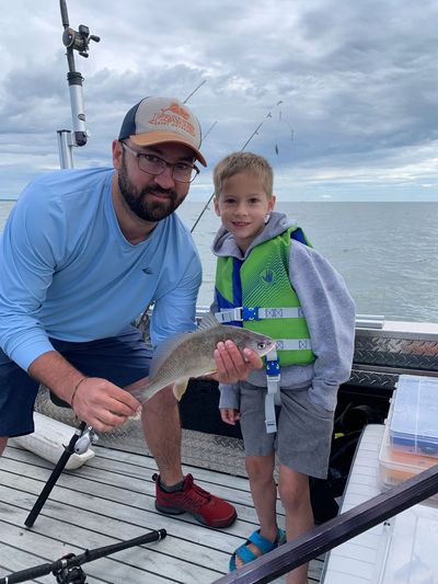 Father and son holding a fish while fishing together on the Great Lakes