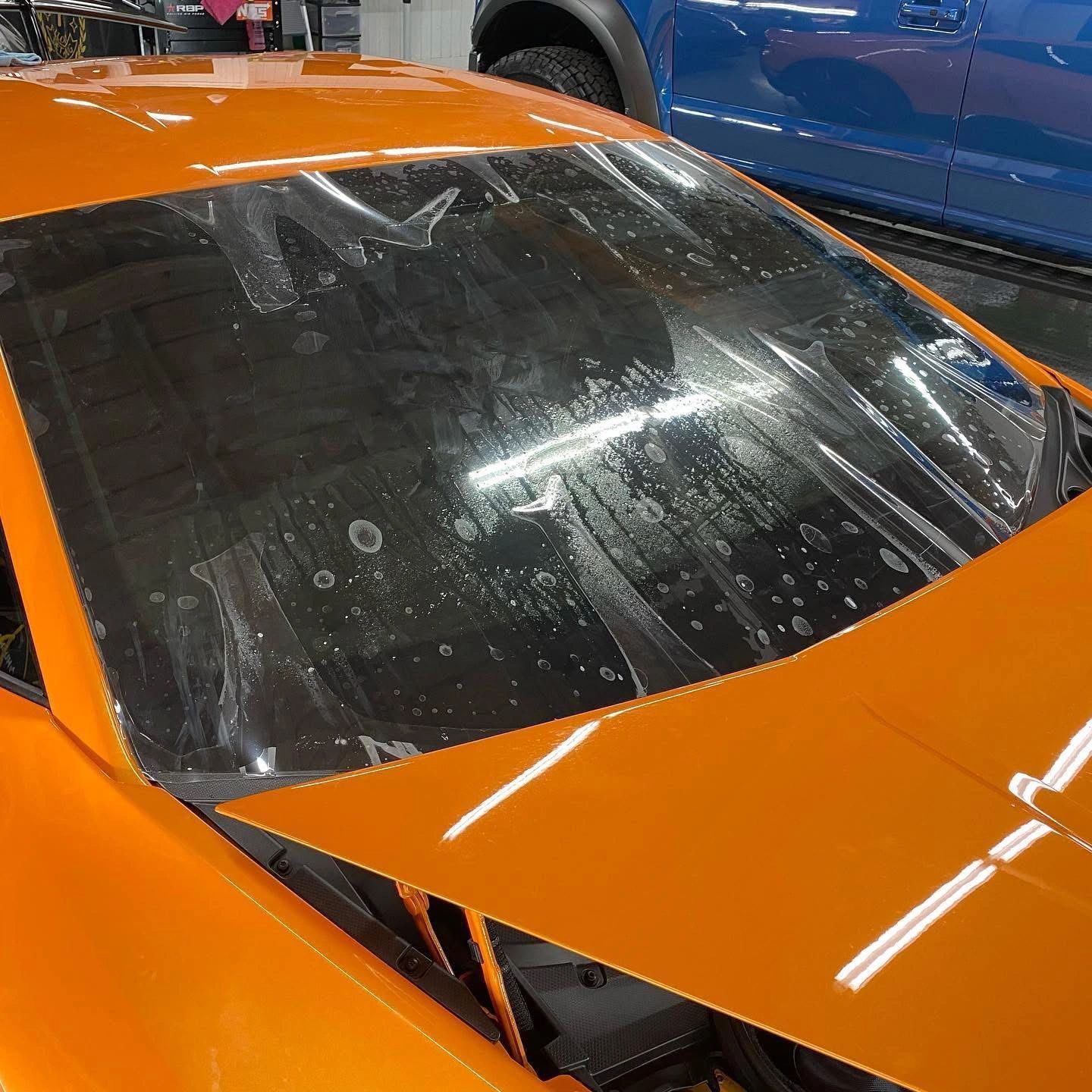 Exterior windshield protection film on orange Lamborghini, protects against rock chips and damage