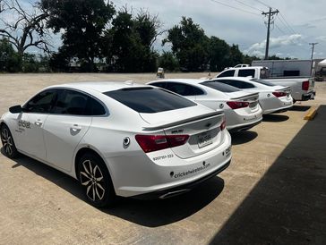 White sedan with newly installed dark dyed window tint, showcasing a classic, uniform look.