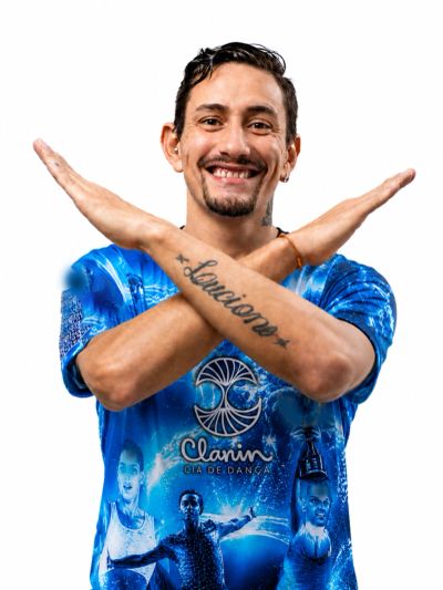 Homem sorridente com os braços cruzados em X.