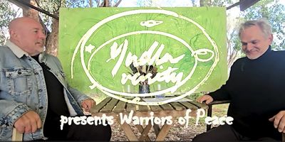 Two men seated outdoors with 'Yudhisthira presents Warriors of Peace' text overlay.