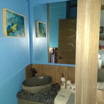 Custom bathroom with Volcanic rock sink and river rock accents throughout