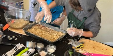 Two people preparing food in a kitchen.