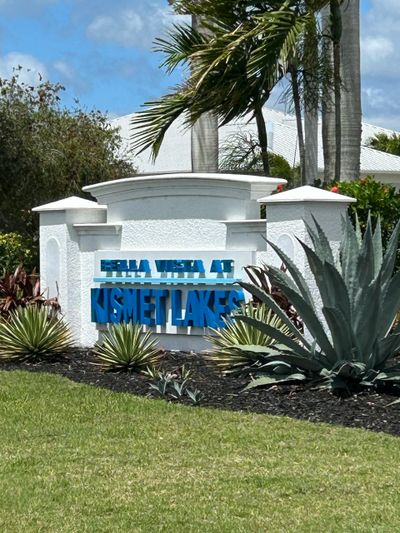 Entrance sign for Bella Vista at Kismet Lakes with surrounding greenery.