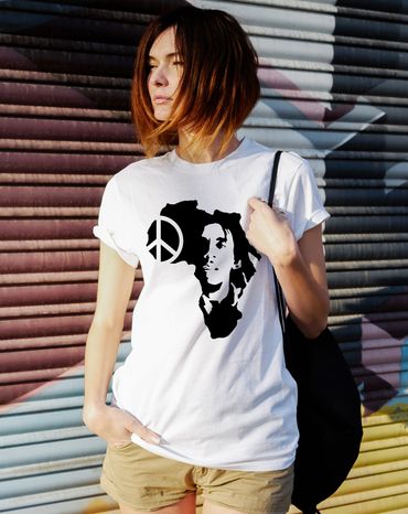 Woman wearing a white t-shirt with a black Africa map and peace symbol design.