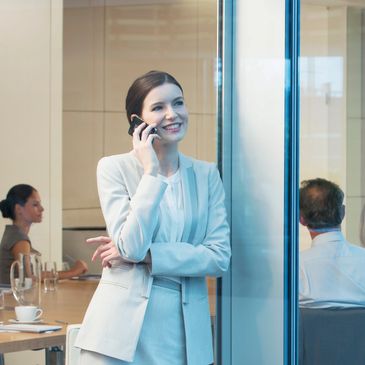 Businesswoman talking on cell phone in meeting