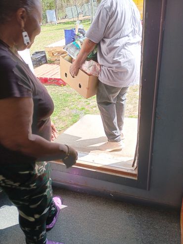 3.5.26 LWCWC associate helping recipient with food box.