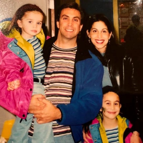 Happy family of four posing together indoors.