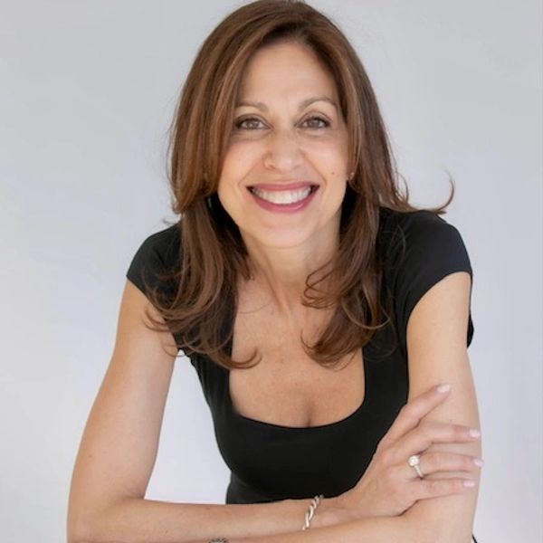 Smiling woman with brown hair wearing a black top.