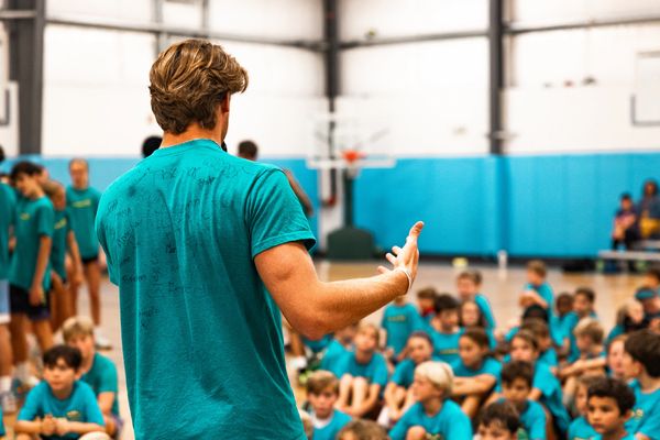 Camp coach showing kids about basketball