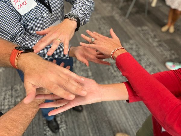 A group of people showing their hands with rings and watches.