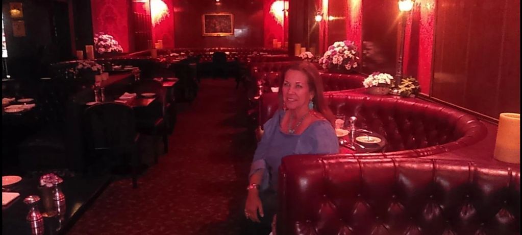 A woman sitting in a dark lighted restaurant