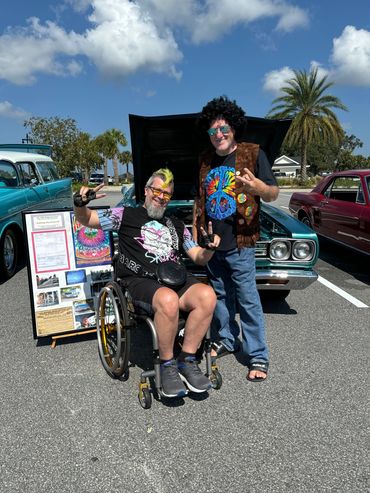 Randy in wheelchair next to a hippie at Grovestock.