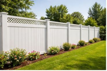 White vinyl fence with lattice top in a landscaped garden.