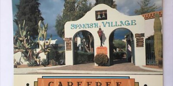 Entrance archway of Spanish Village decorated with rustic lanterns.