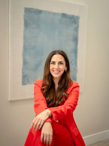 Woman in a red suit smiling.