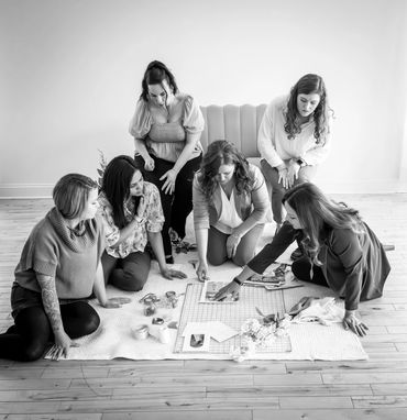 Six team members working on a design board placed on the floor.
