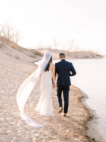 Bride and groom taking a walk at the Sandbanks Provincial Park in Prince Edward County