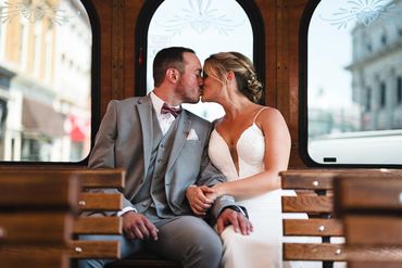 Bride and Groom kissing while sitting at the back of a trolley.