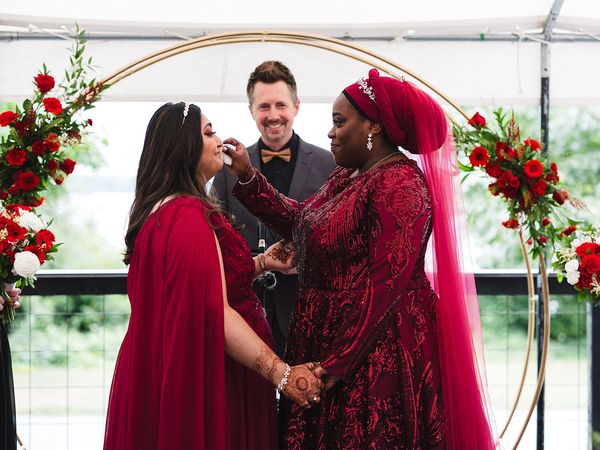 Bride wipes away tears of her bride during their ceremony at the River Mill Restaurant