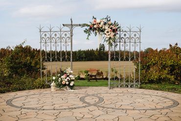 Ceremony arches made from two wrought iron doors behind a flagstone infinity circle ceremony space.
