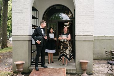 Team dressed in black, white and gold, standing in an arched doorway.