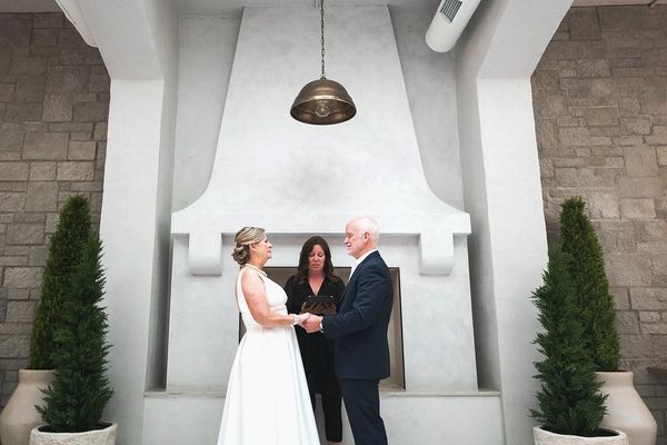 Mature couple getting married in front of the fireplace at Heist Restaurant and Wine Club