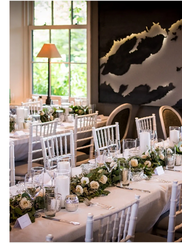 A map of the thousand island on the wall in a dining area adorned with white decor and greenery