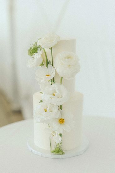 Two tier wedding cake with white flowers and green stemp