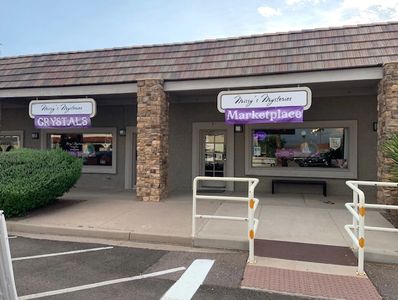 Storefronts with ‘Crystals’ and ‘Marketplace’ signs in a shopping plaza.