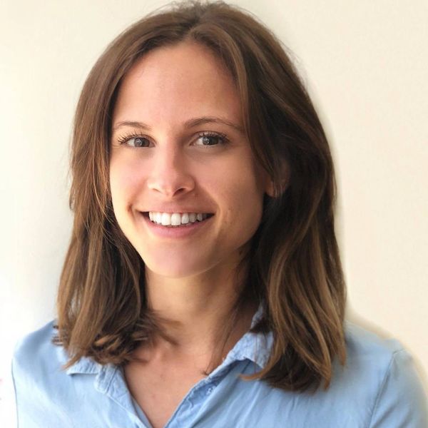 Smiling woman with long brown hair and bright eyes.