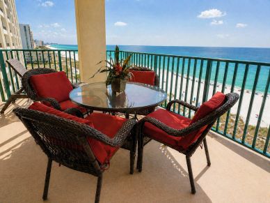 Jade East 710 balcony seating area with five cushioned chairs, table, and direct Gulf view.