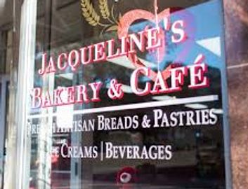 Window sign for Jacqueline's Bakery & Café offering breads, pastries, ice cream, and beverages.